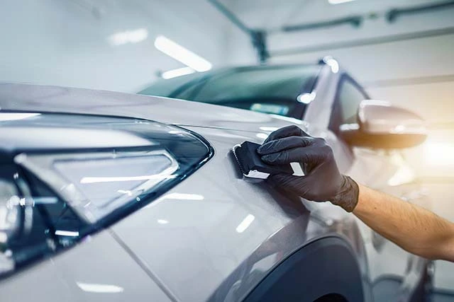 A man checking his car's paint