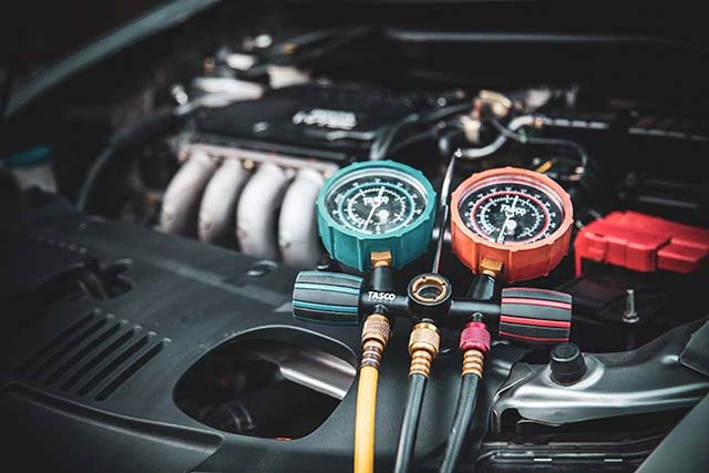 Two gauges under the hood of a car