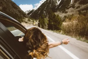 Woman hanging out from the window of a car