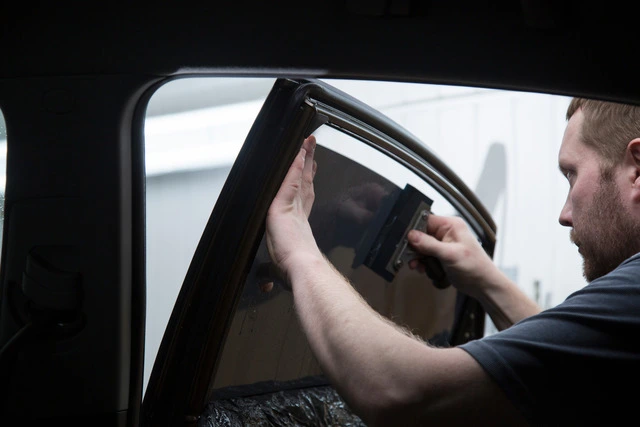 Man-applying-tint-to-a-car-window