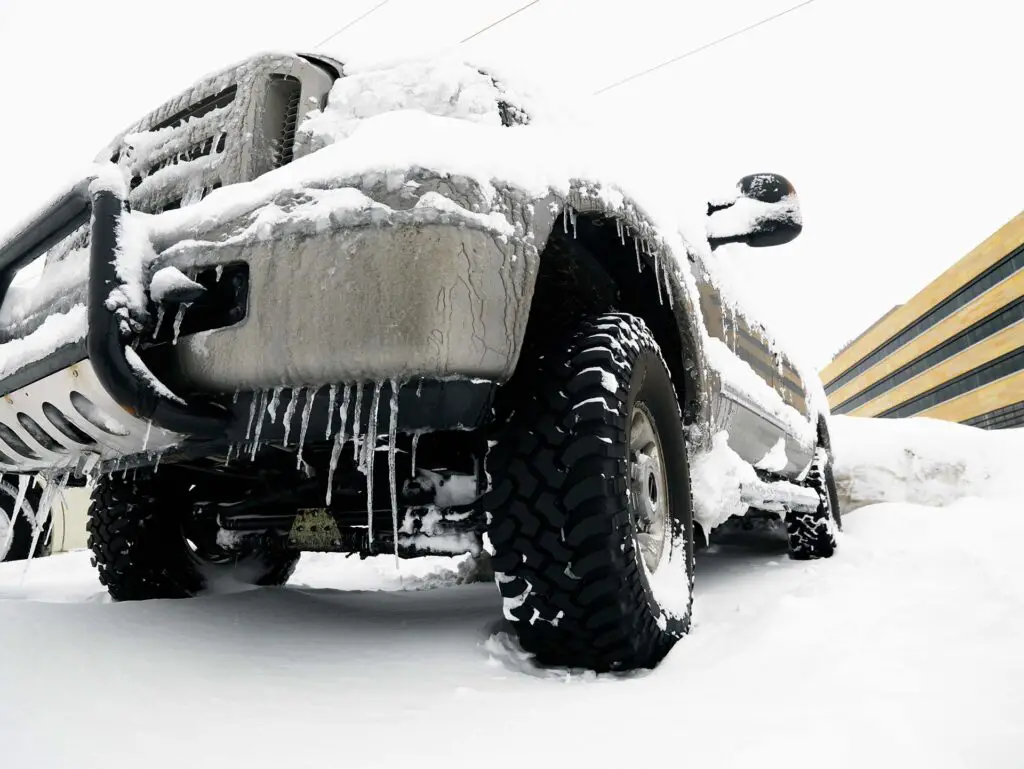 A big SUV covered in snow and ice