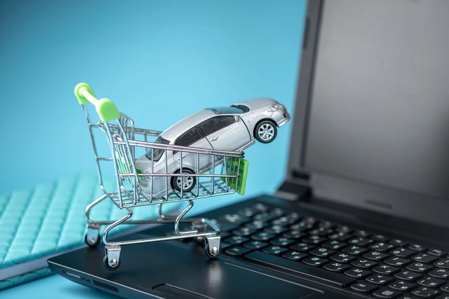 Shopping basket with car on laptop keyboard