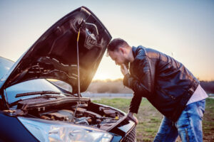 A man looking under the hood of his vehicle