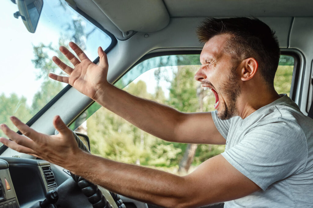 A man yelling behind the wheel
