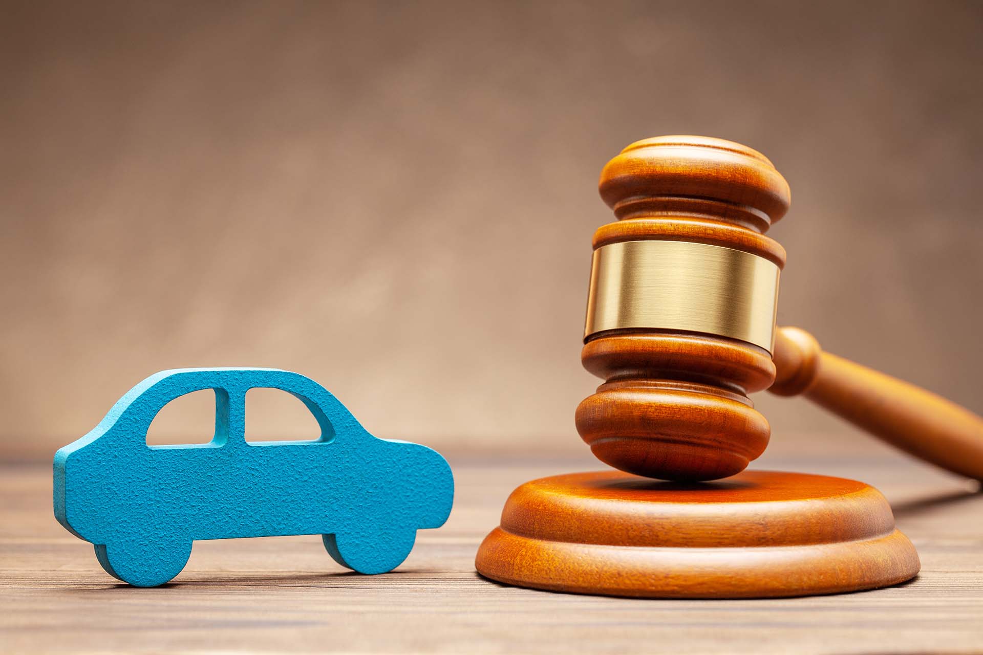 Car and judge gavel on brown background. Concept of selling a car by auction or accident sentence.