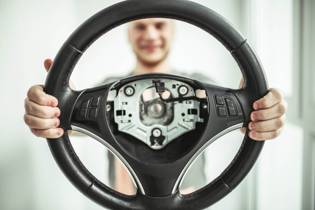 Man holding a detached steering wheel