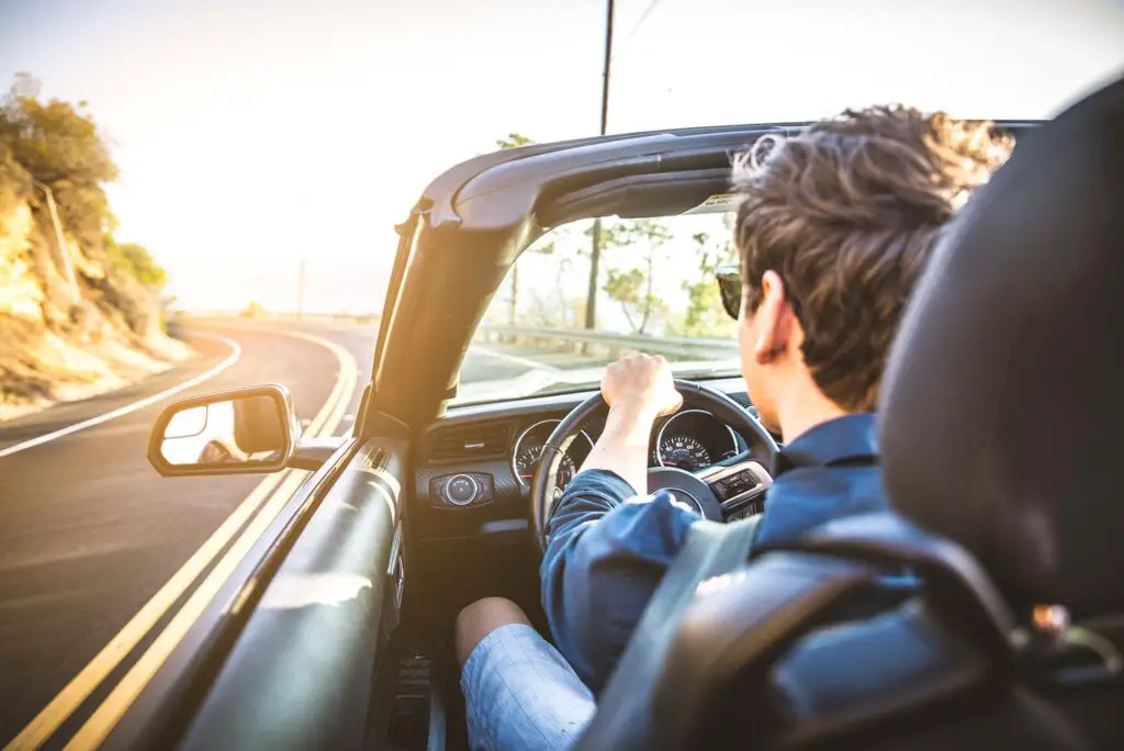  A man driving a convertible car