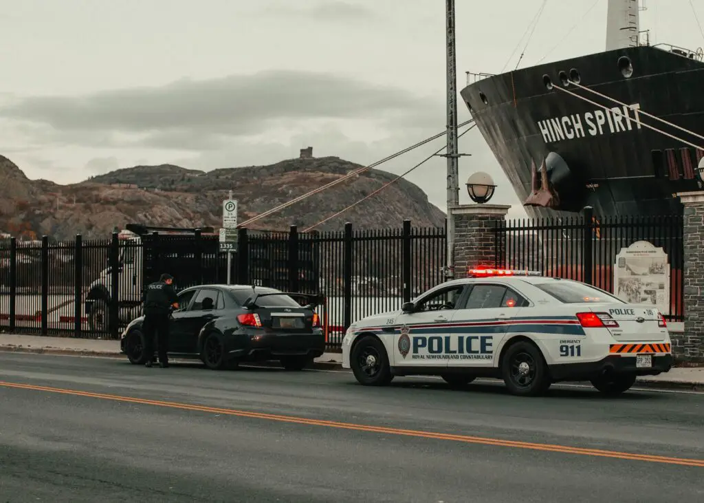 A police car and a policeman writing a ticket