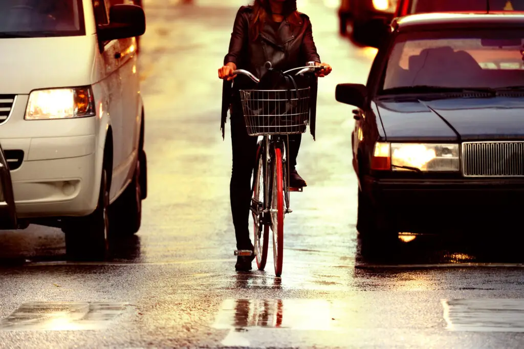 Girl on a bike between cars