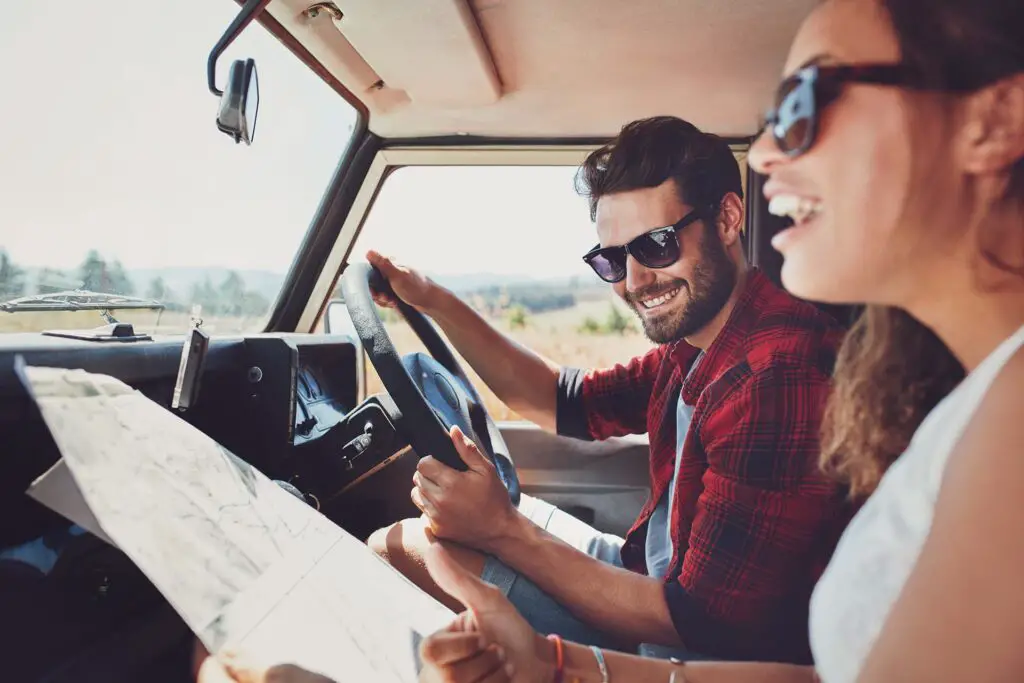 Young couple in a car looking at a map