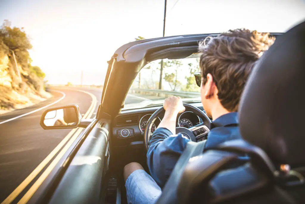 Man in a convertible driving on the road