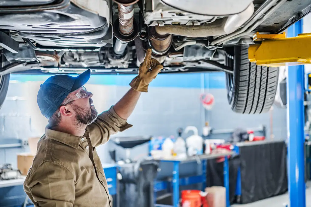 A professional mechanic performing car undercarriage inspection