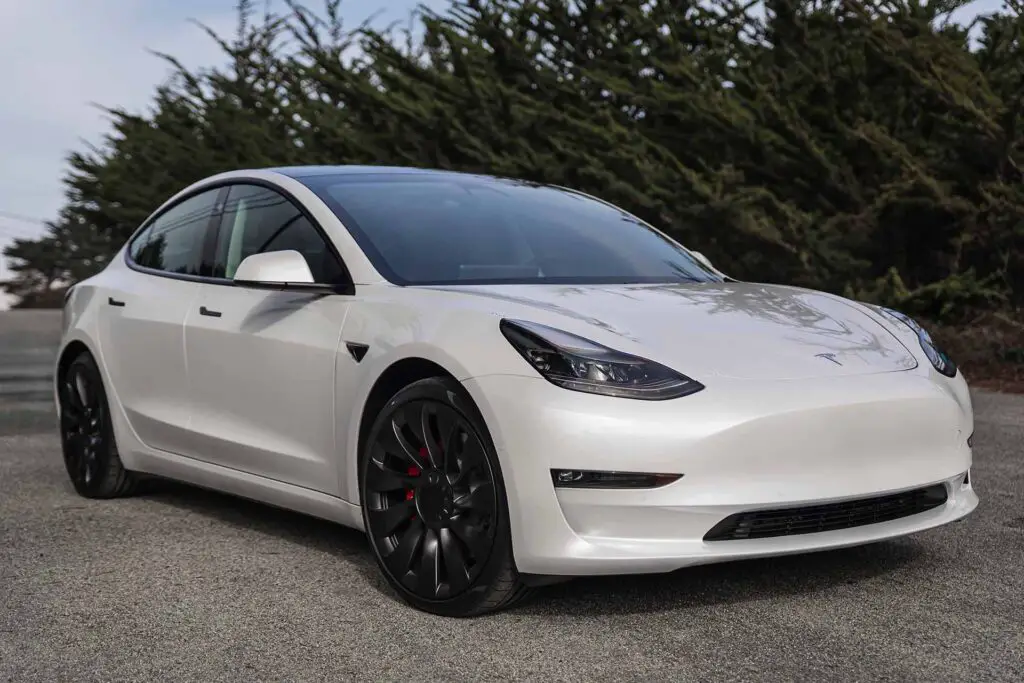 Moss Beach USA - January 1, 2021: Pearl white electric Tesla Model 3 dual motor performance AWD car with 20 inch Uberturbine wheels near San Francisco