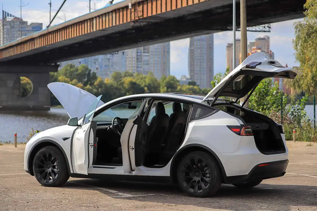 2022: White car Tesla Model Y with open doors