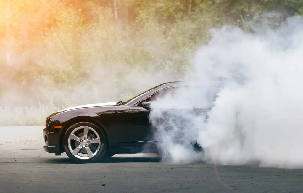 Drift - black muscle car makes lot of smoke