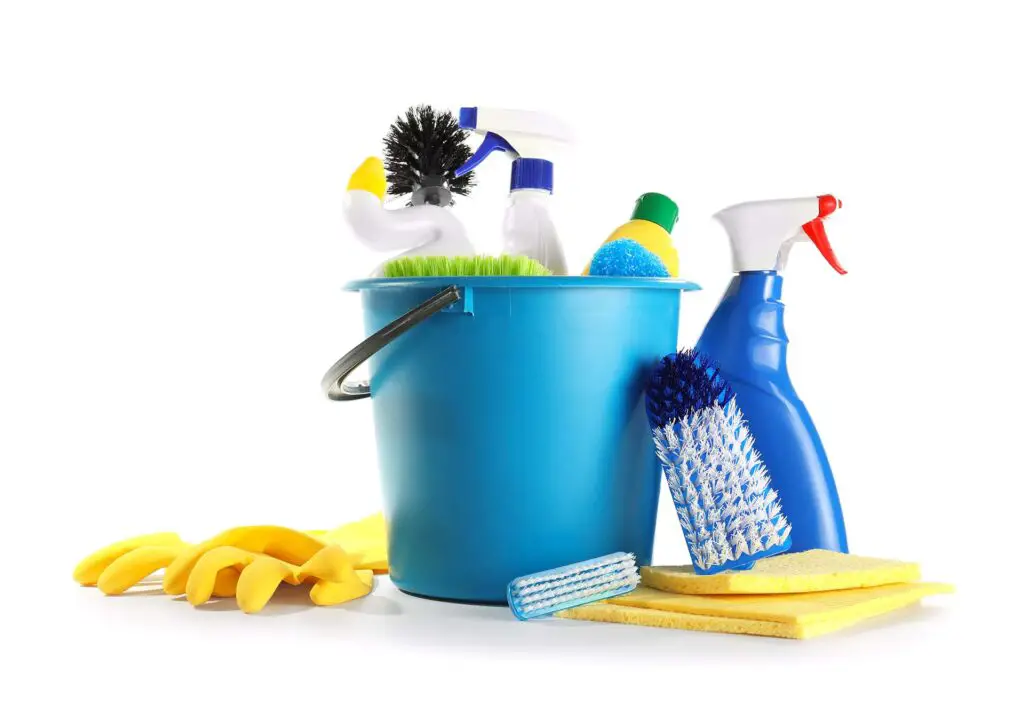 Bucket with cleaning supplies on white background