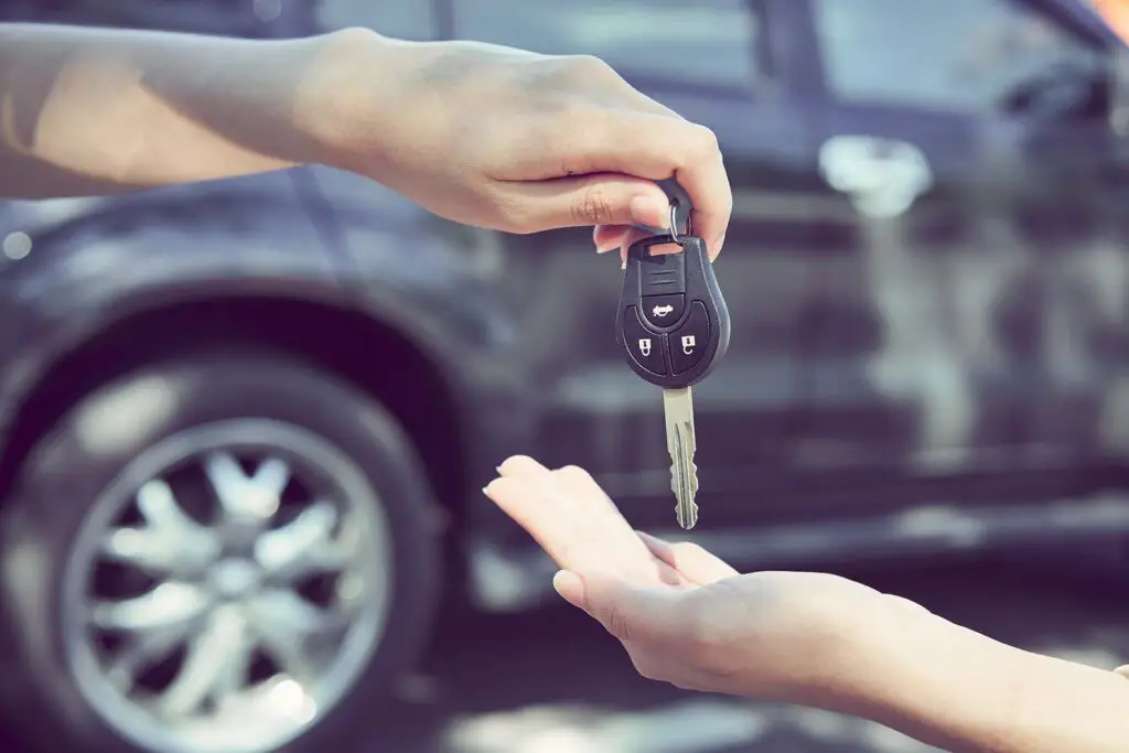 A person handing car keys to another person