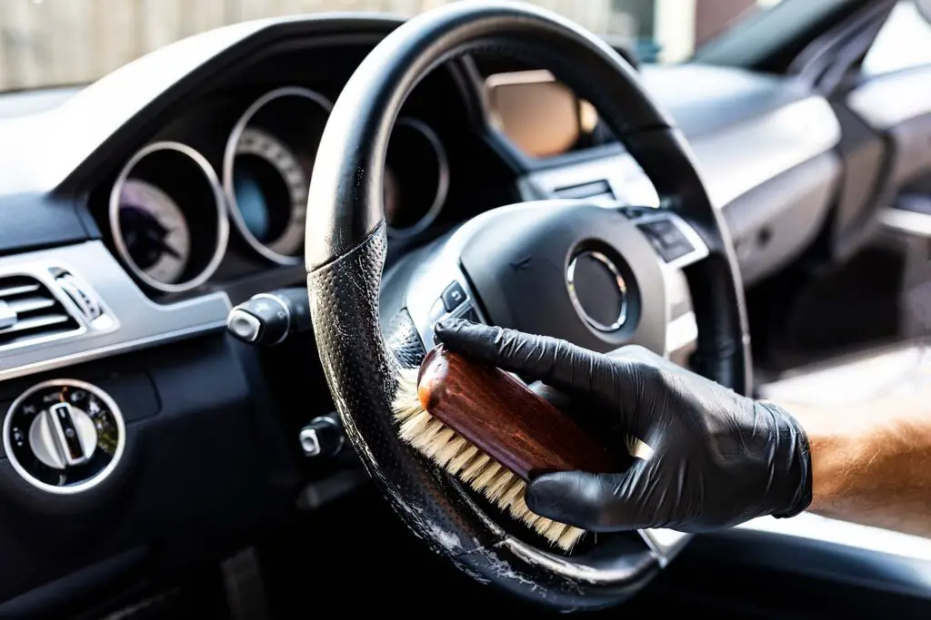 A person cleaning a steering wheel with a cloth