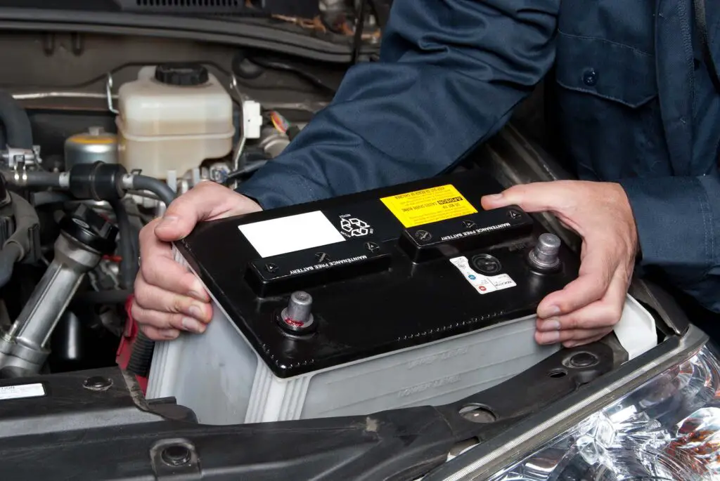 Man pulling out an old car battery