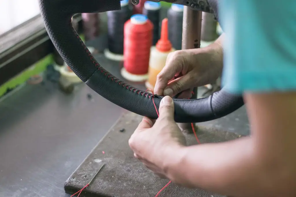 The mechanic change cover of the steering wheel of the car. Renewal of steering wheel cover.