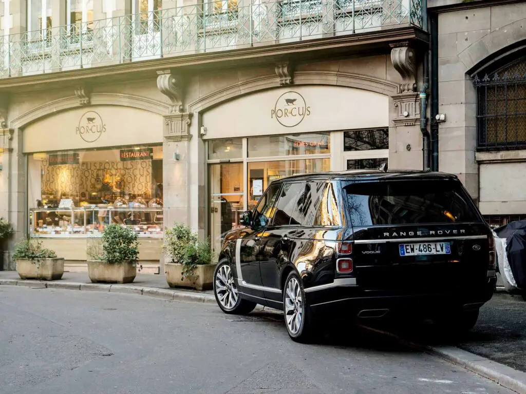 STRASBOURG, FRANCE - 13 MAR, 2018: New Range Rover Land Rover Vogue, the luxury British SUV parked in central French street near butcher shop Porcus Place du Temple Neuf