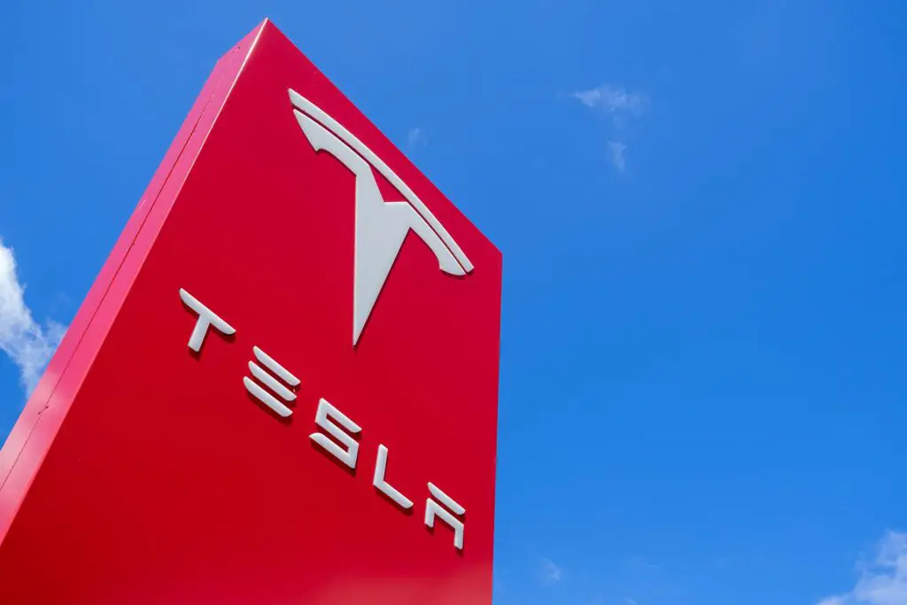 Tesla dealership sign against blue sky