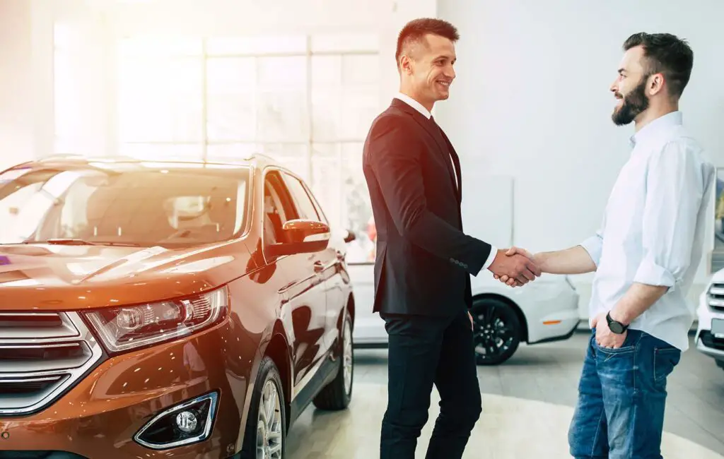 Two men shaking hands in a dealership
