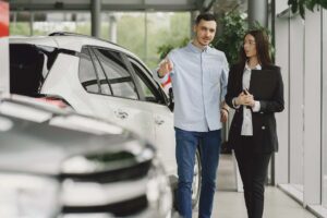Woman in dealership shop talking to a vehicle dealer