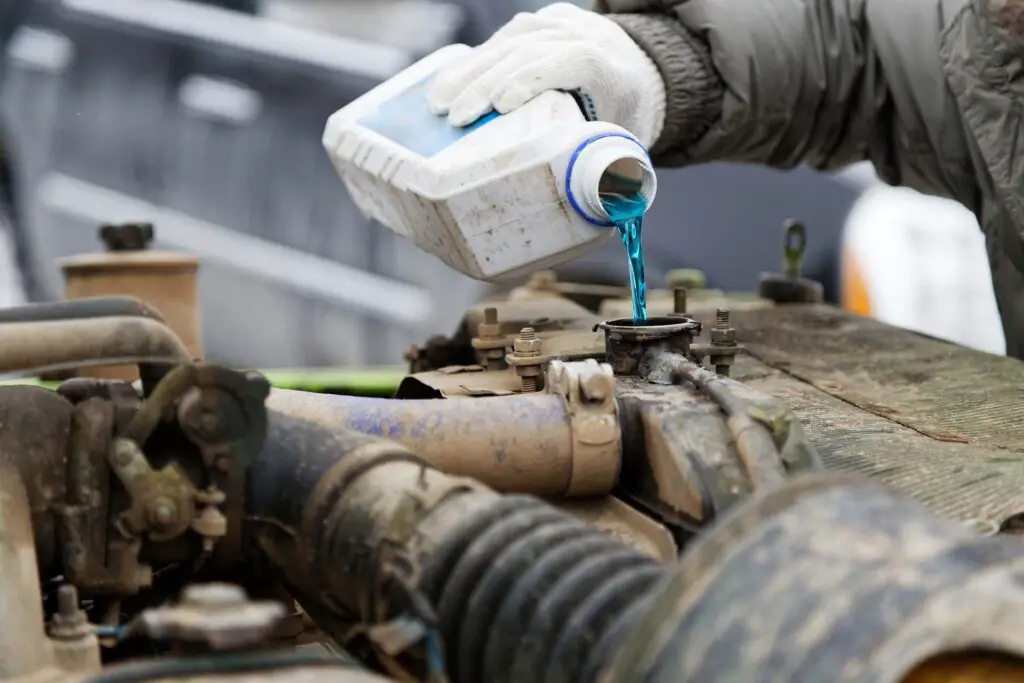 Person pouring premixed engine coolant into the cooling system