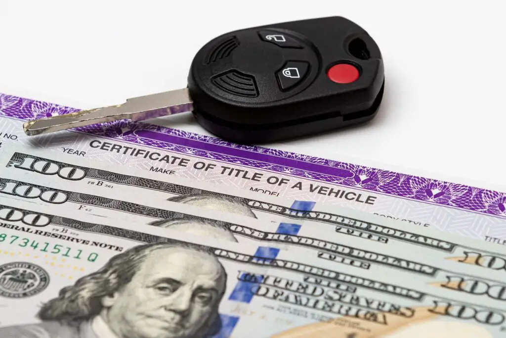 Car key, vehicle title, and dollar bills