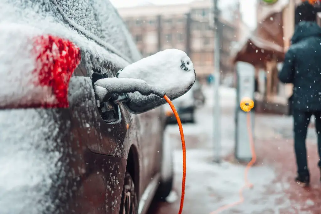 Electric car plug charging in the winter. Amsterdam, Netherlands