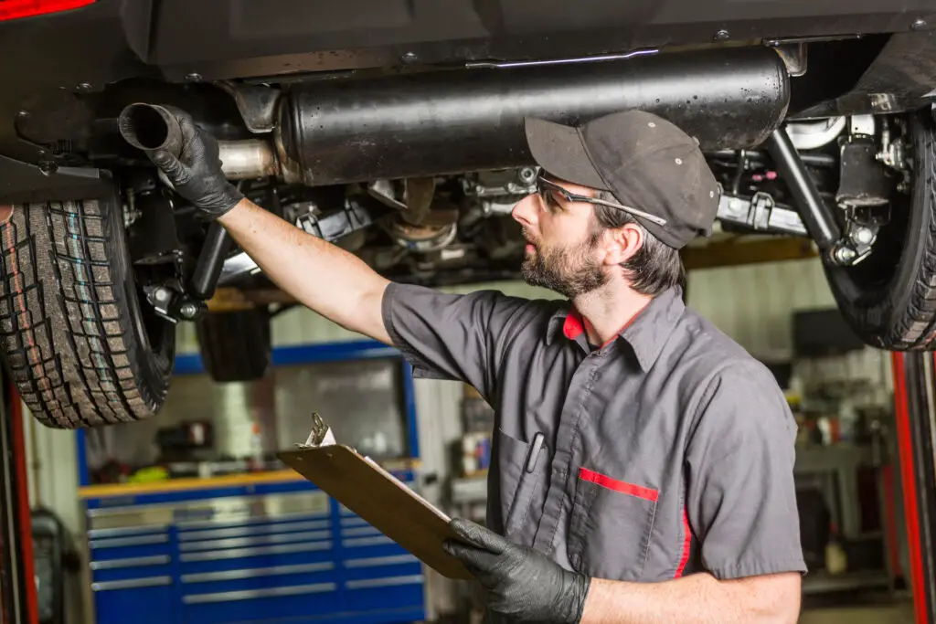 A mechanic checking a muffler