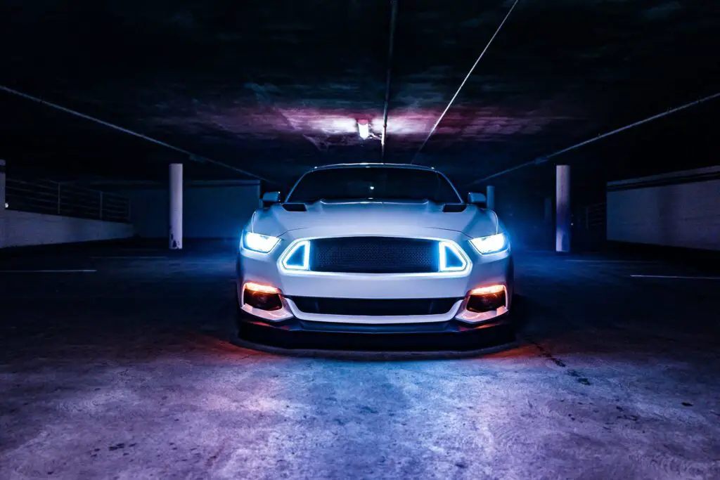 white car with turned on lights in a garage