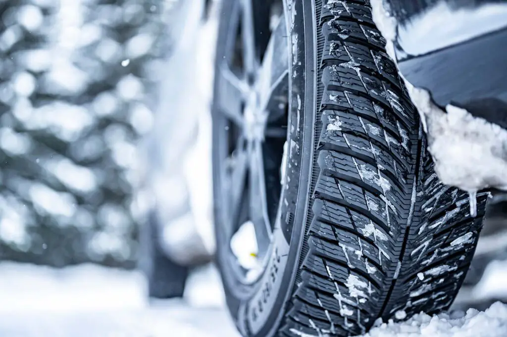 A close-up of a car tire in snowy weather
