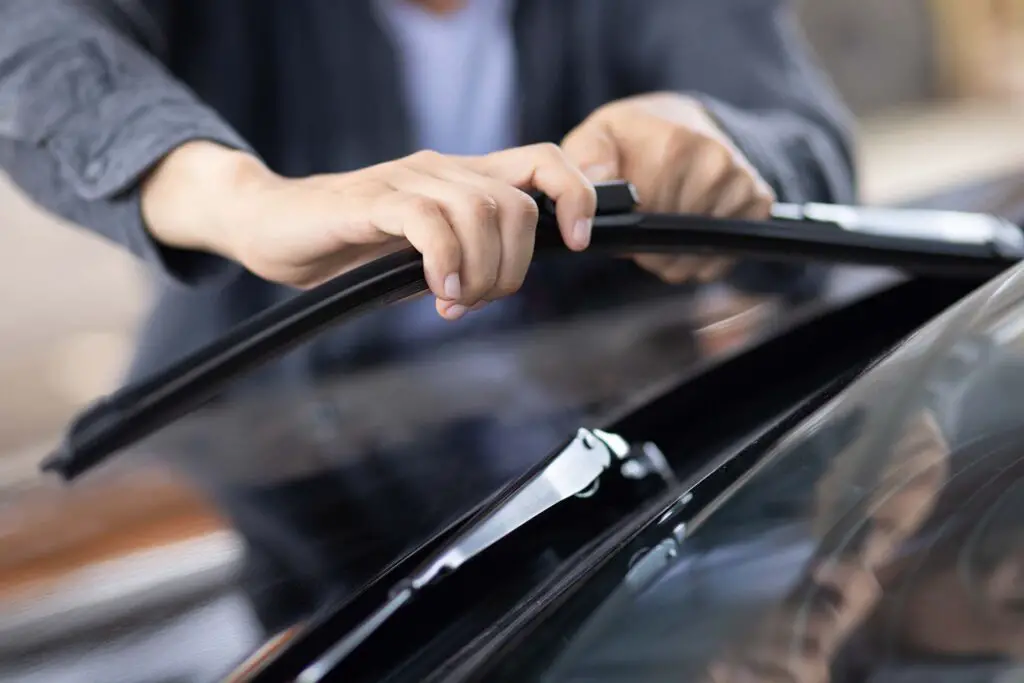 A man replacing windshield blades