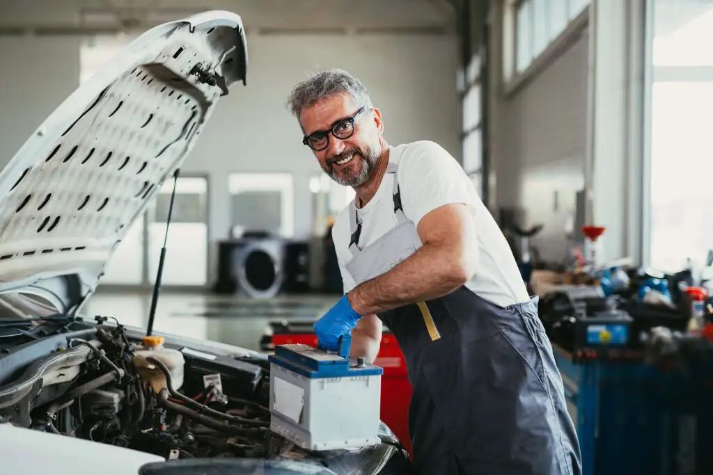 A mechanic changing the battery in a car service