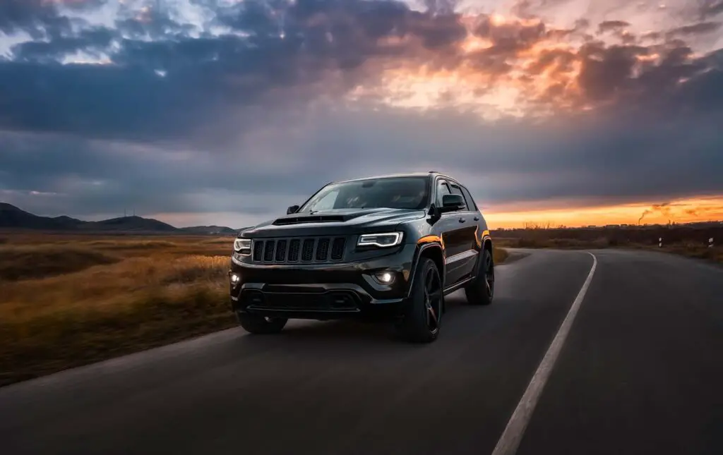 Jeep Grand Cherokee on the road at sunset