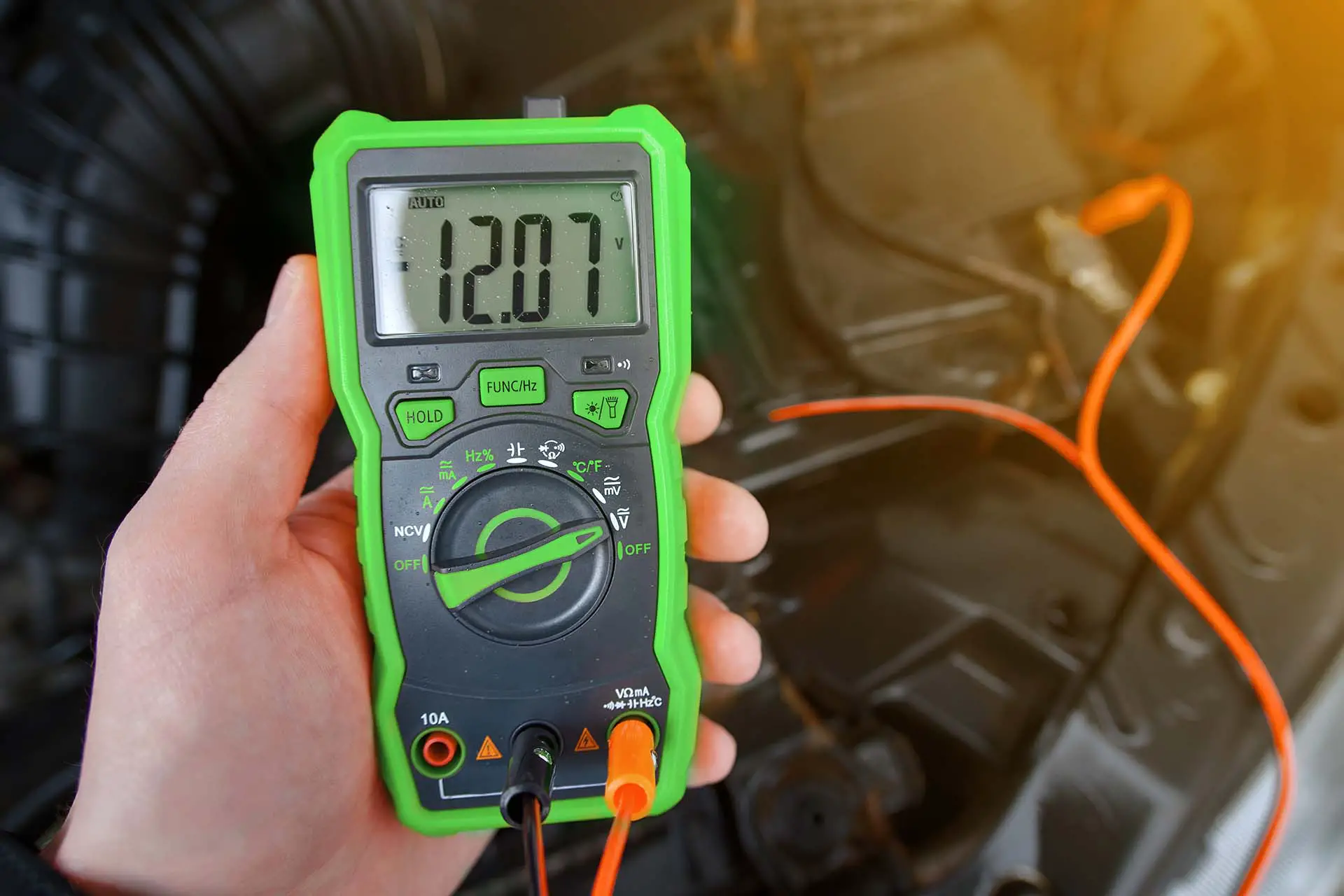 Checking car battery with digital multimeter. Check car battery using voltmeter. Man check up voltage level, alternator produce 12.07 volts. Bad alternator won't sufficiently charge the battery