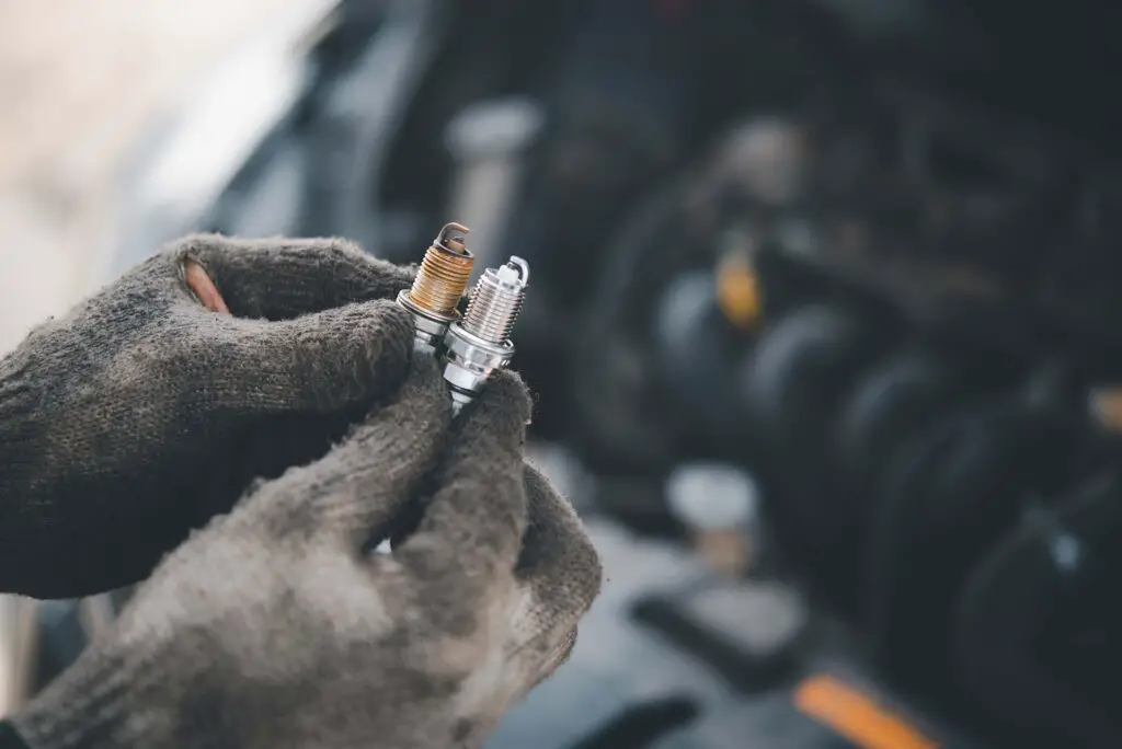 A person holding the old and new spark plug