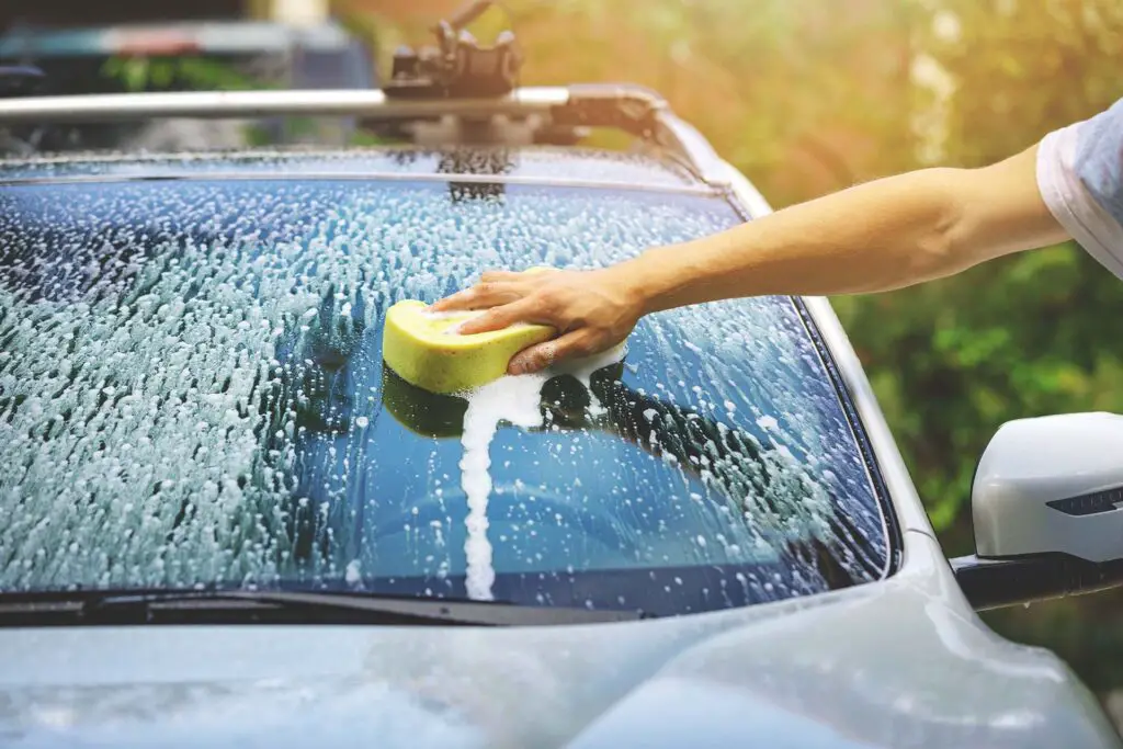 hand car wash - washing windshield with sponge