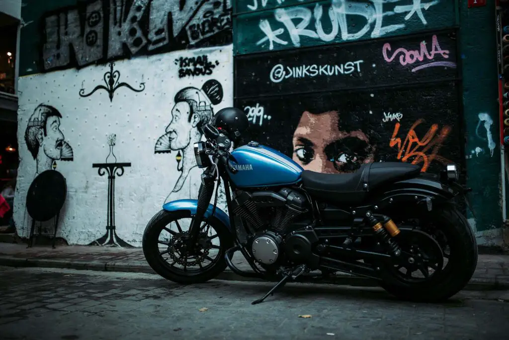 A blue and black Yamaha motorcycle parked by a wall