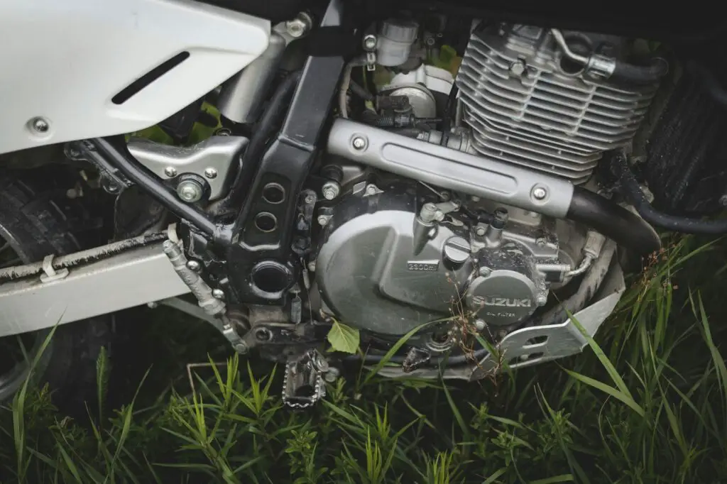 Black and silver Suzuki motorcycle's engine on green grass