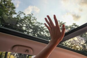 Person touching a sunroof inside the car