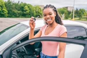 A Young black teenage driver seated in her new car