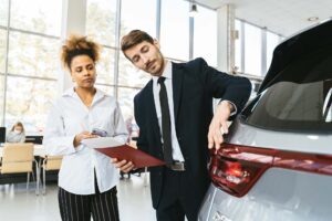 A sales representative at a car dealership talking to a customer