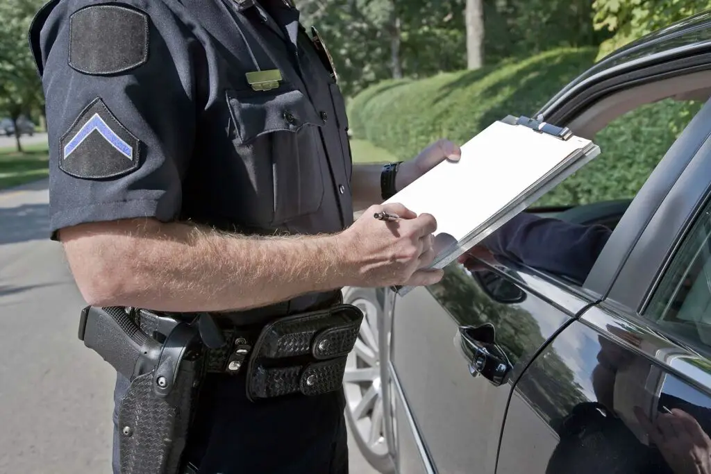 Policeman writing speeding ticket.