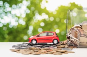 Small toy car and money coins on table