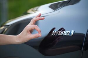 Purchaser hand showing thumb up sign at hybrid car new effective vehicle.