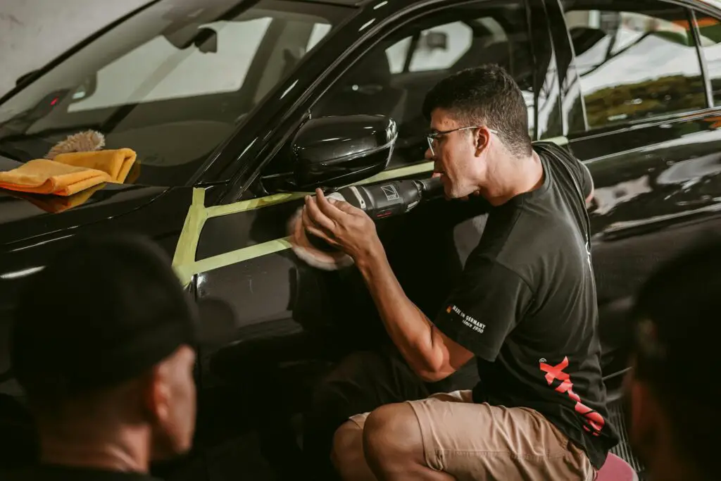 A professional polishing a car