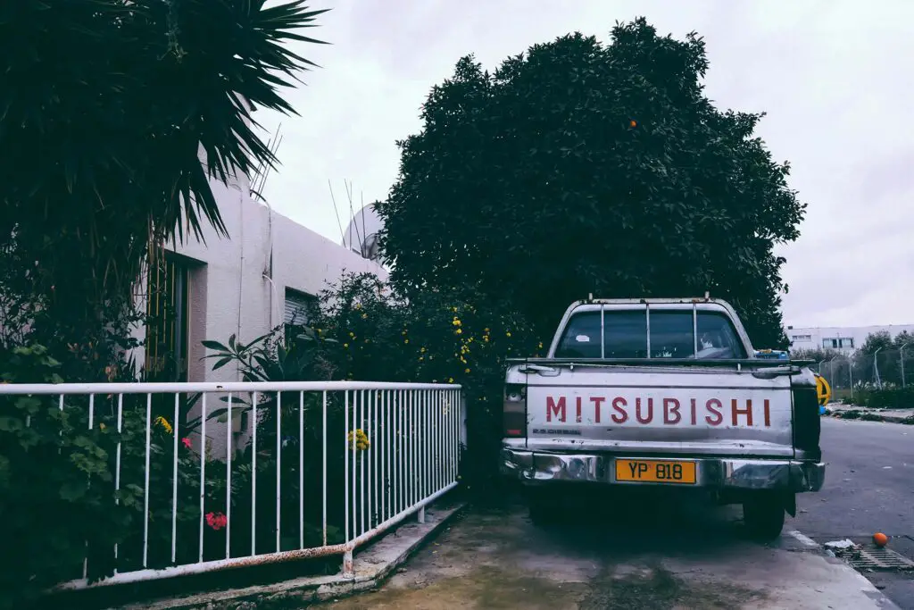 A Mitsubishi pick-up parked in front of a house